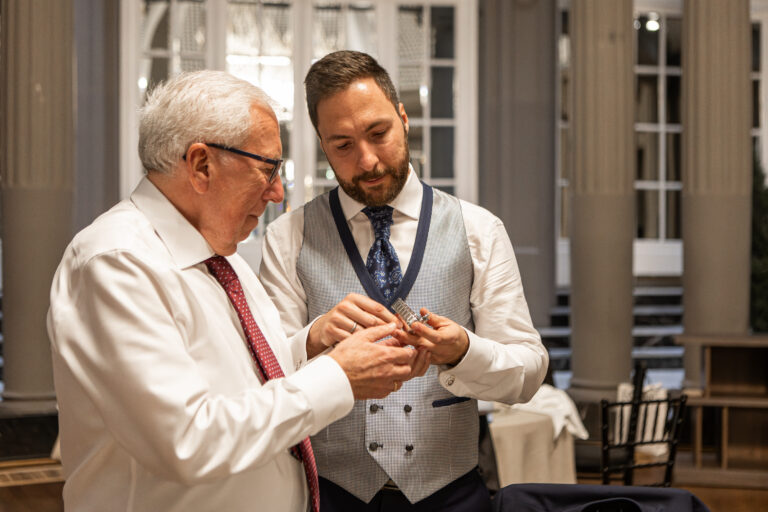 El novio entrega un regalo a su padre durante el banquete. Ambos emocionados. Fotografia emocional de bodas en Zaragoza